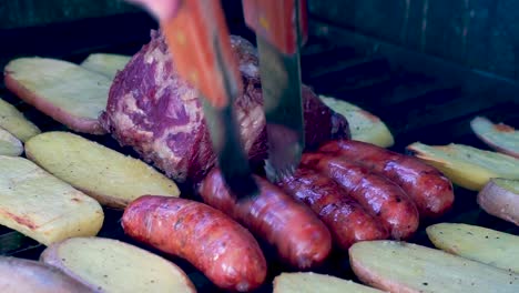 closeup shot grilled meat with chorizos, cheesetop tortillas, guatemalan beans and grilled potatoes smoking and juicy preparation ready to eat family at a summer season day [hd1920 x 1080] fps 29