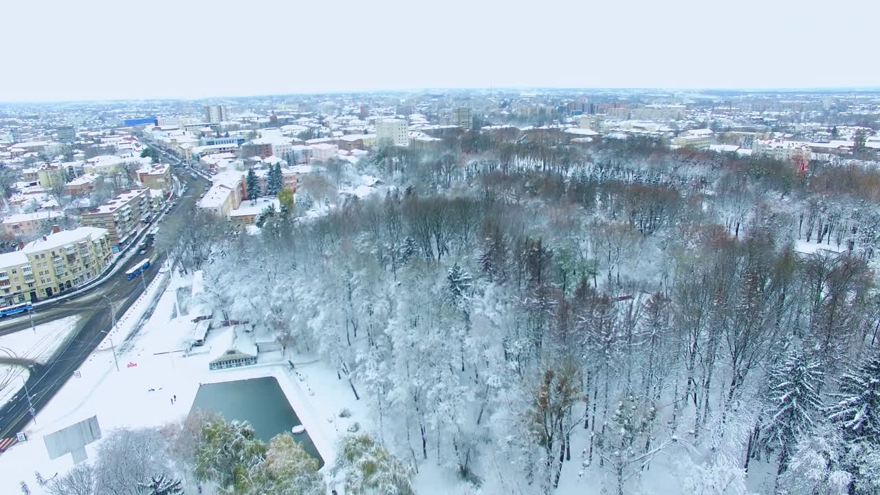 City in snow on winter season. Beautiful urban panorama with buildings, parks and roads from top view.