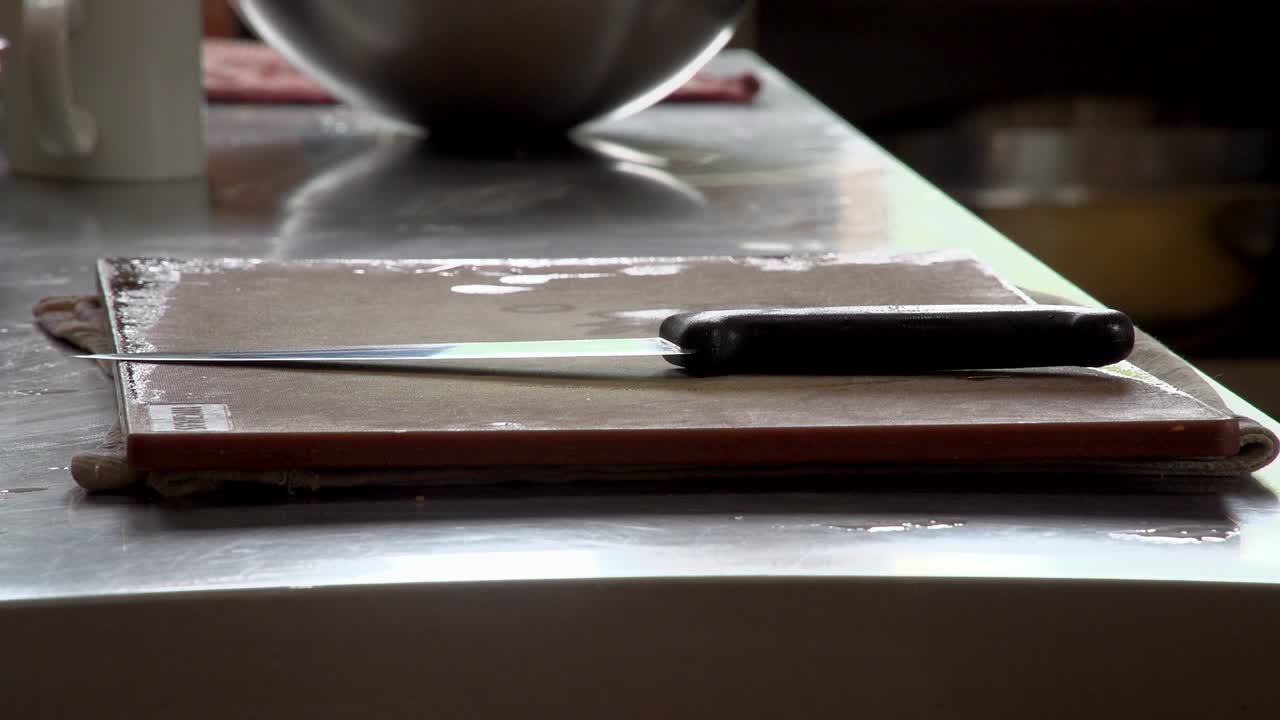 un cuchillo afilado está listo en una tabla de cortar en una cocina profesional