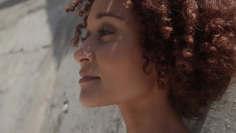 primer plano de una joven mujer afroamericana relajándose en la playa bajo el sol 4k