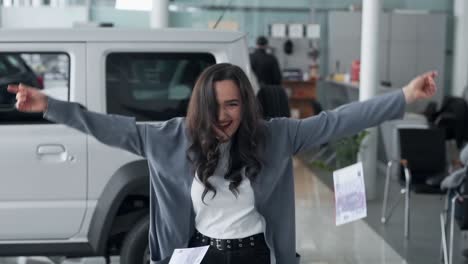 beautiful woman scattering money in a car dealership by car