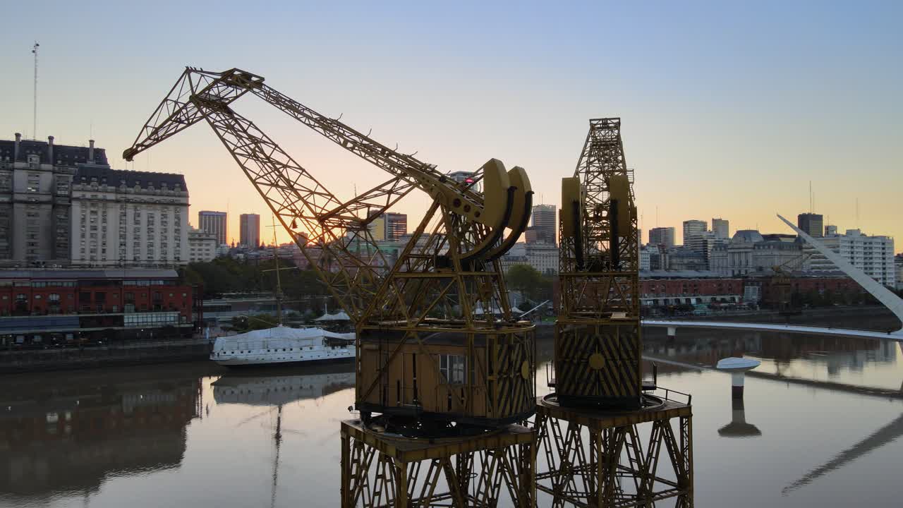 крутящаяся антенна портовых кранов на берегу реки в сумерках, буэнос-айрес