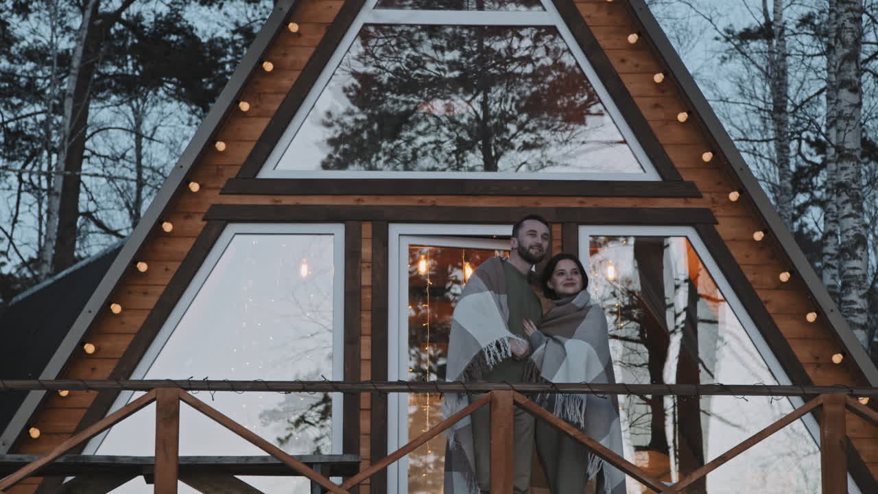 Couple Standing on Porch of A-Frame Cabin