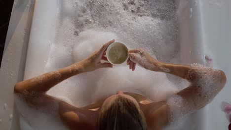 caucasian woman drinking coffee while taking bath in hotel