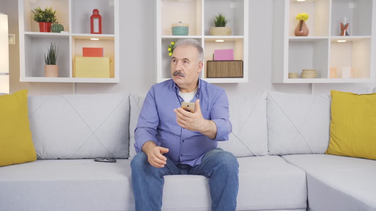 el viejo está mirando el teléfono. el viejo usa las redes sociales.