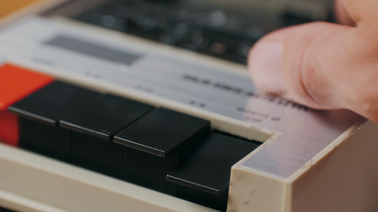 Hand operating a vintage audio cassette player