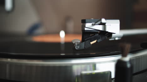 vintage retro record player needle rides over a vinyl record