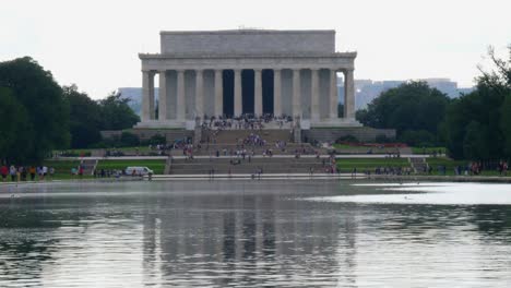 Slow-tilt-up-from-the-water-to-the-front-steps-of-the-Lincoln-Memorial-taken-from-the-reflection-pond-with-people-in-the-foreground