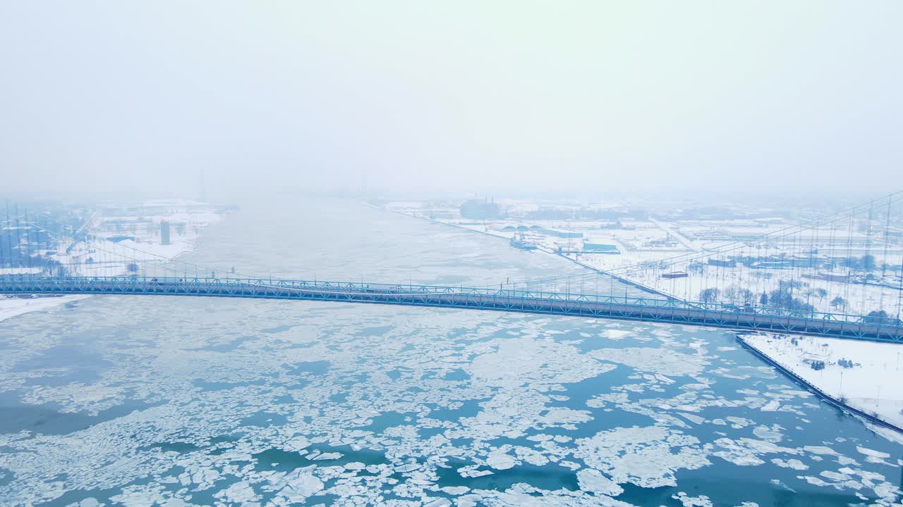 Ambassador Bridge spans icy Detroit River under heavy snow and cloudy winter skies