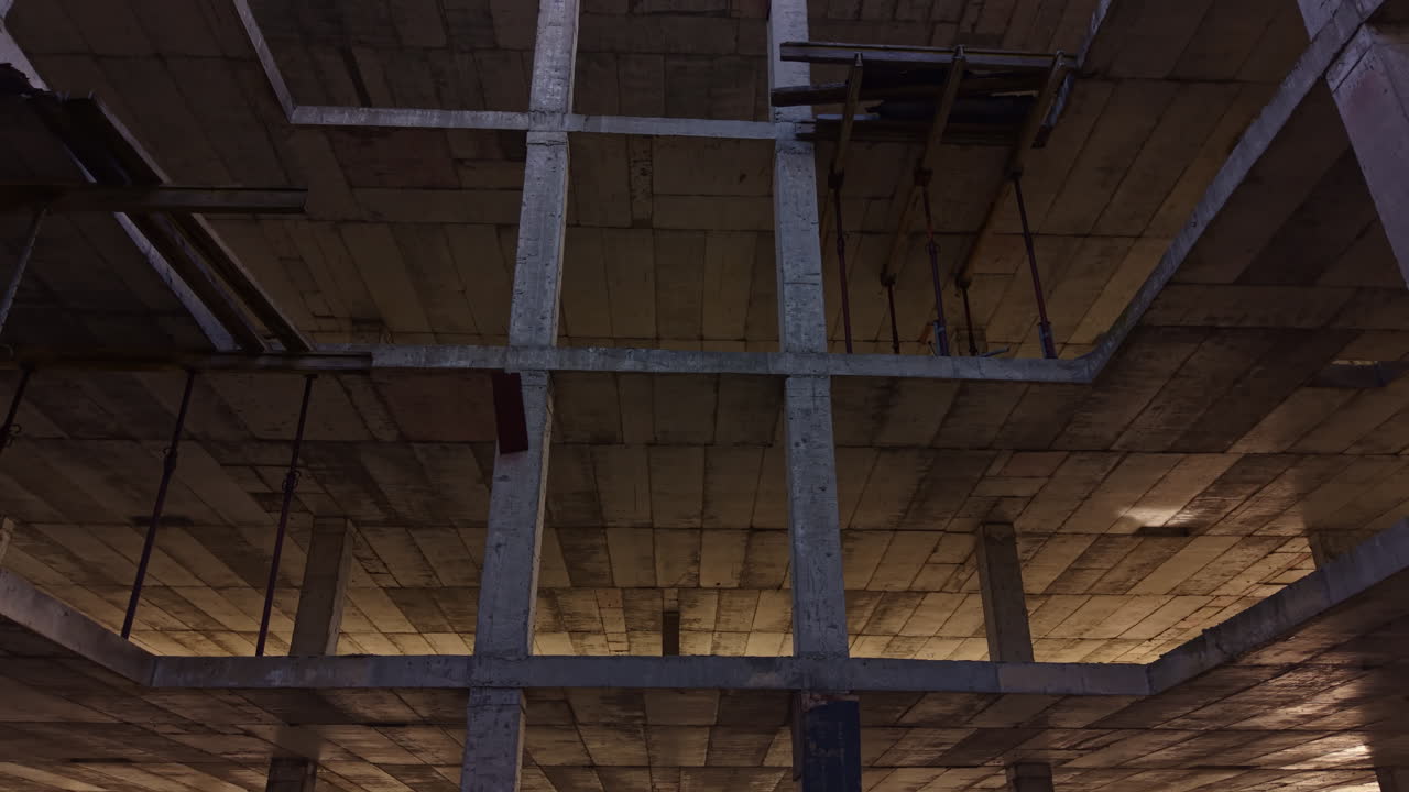 Struttura in cemento che si protende verso il cielo in un moderno paesaggio urbano, mostrando i progressi della costruzione al crepuscolo