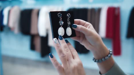 mujer elige pendientes en la tienda primer plano, cinematográfico
