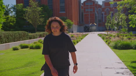 woman walking in a park near buildings