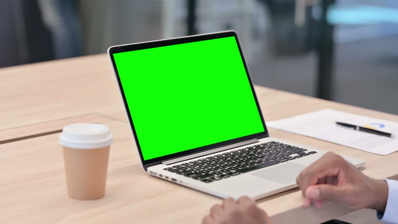 African Businessman Using Laptop with Green Screen