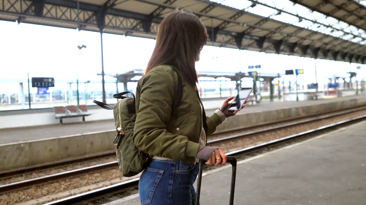 mujer con equipaje en una estación de tren