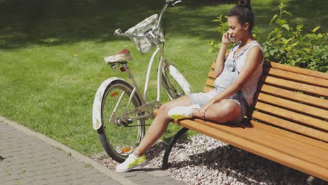 woman talking phone on bench