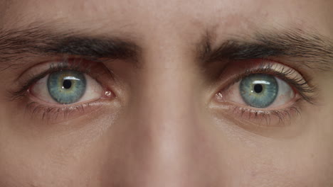 close up eyes opening young man with beautiful blue iris optometry concept