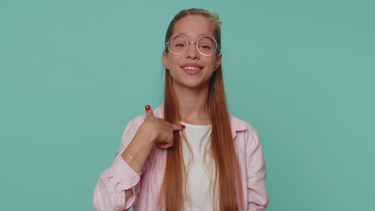 사랑스러운 예쁜 십대 소녀 아이는 카메라를 보고 전화 제스처를 하고 있습니다. "헤이, 다시 전화해 ⁇ "