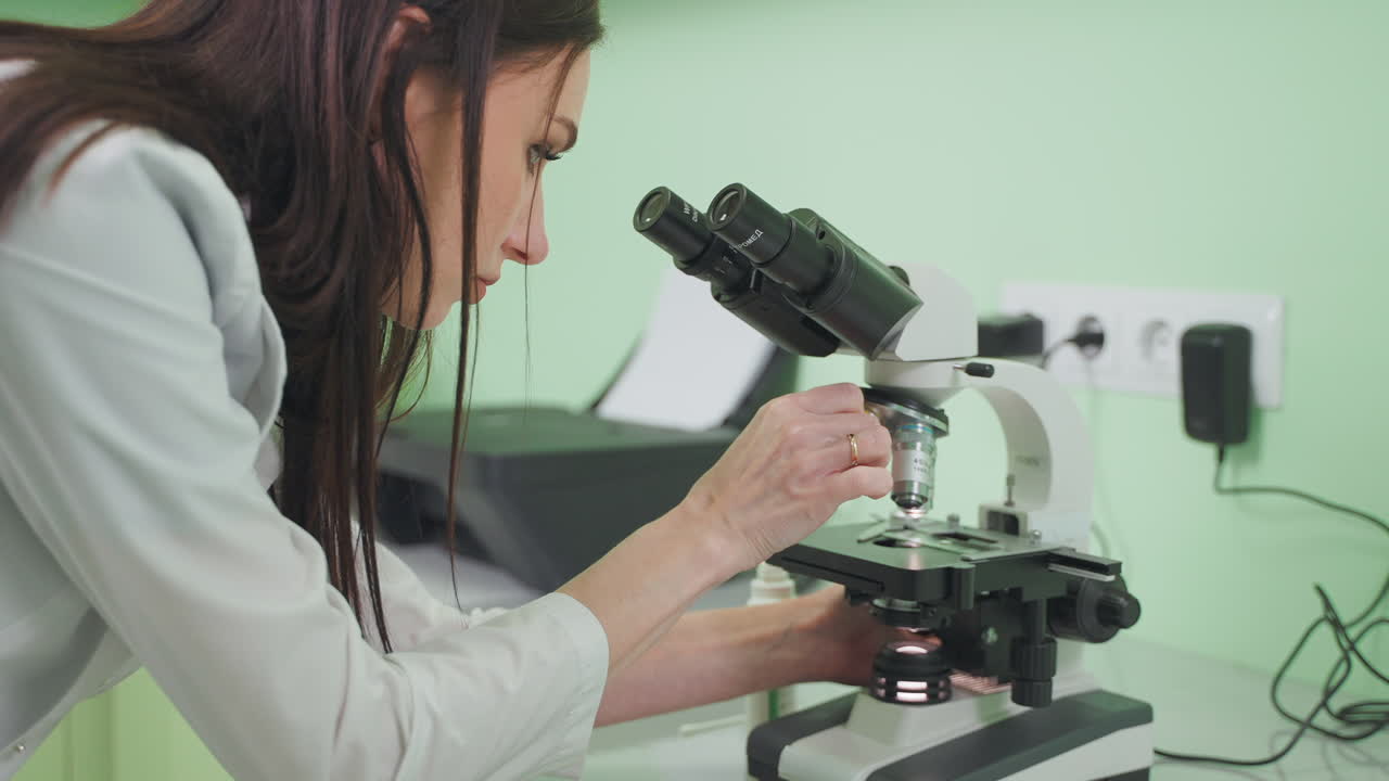 Female Scientist Using Microscope in a Laboratory