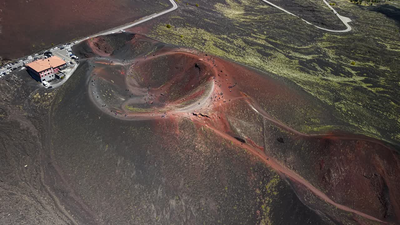Aerial overview establishing twin Silvestri craters and winding access paths and parking lot, Sicily Italy