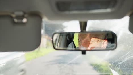 eyes of a man focused on driving reflected in the car mirror