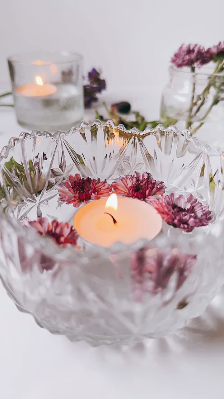 Flydende lys med blomster i en glasskål