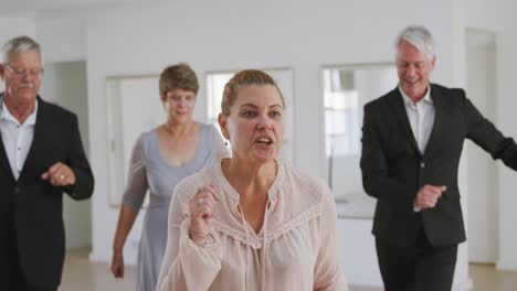 Caucasian-senior-couple-spending-time-together-dancing-in-a-ballroom