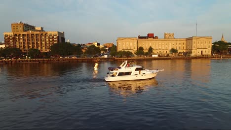 Verfolgung-Eines-Bootes-Auf-Dem-Cape-Fear-River-In-Der-Nähe-Der-Innenstadt-Von-Wilmington,-North-Carolina,-Und-Des-Schlachtschiffs-Bei-Sonnenuntergang