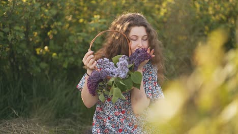 red-haired young woman with a basket of lilac flowers