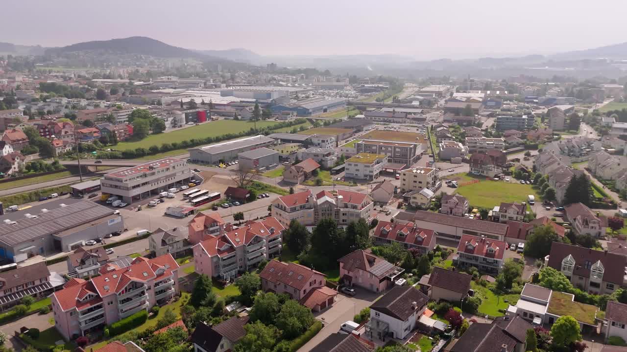 Traffic on intersection Road in wil, Switzerland. Multi family residential apartments at sunny day. Aerial wide shot.