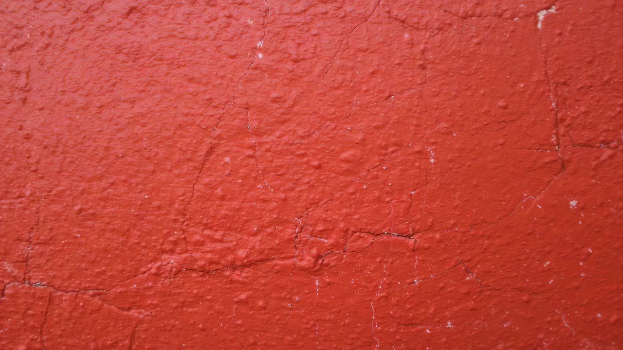 Panning camera right from frame 3 revealing red wall closeup, showing lower seam and vertical crack