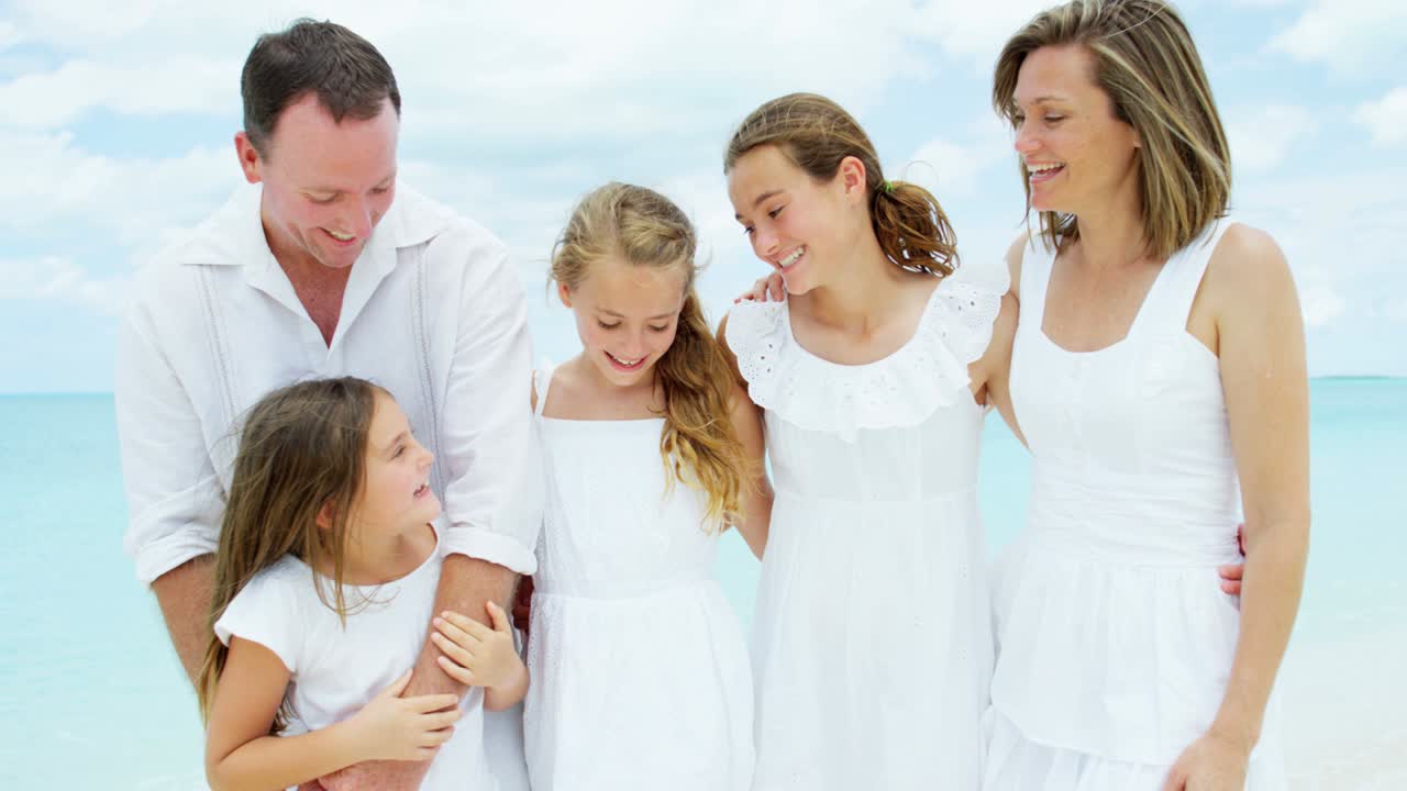 백인 부모와 그들의 어린 딸들이 해변에서