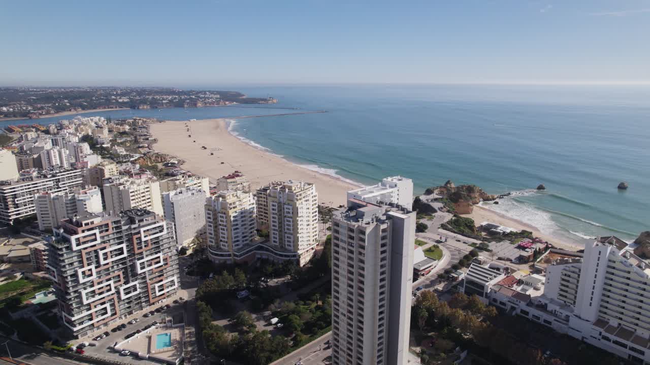 Drone establisher beach Praia da Rocha in Portimao Portugal, behind skyscrapers