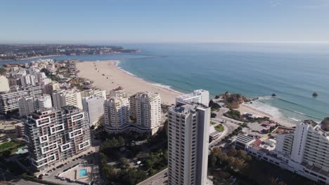 establecedor de drones en la playa de praia da rocha en portimao, portugal, detrás de los rascacielos