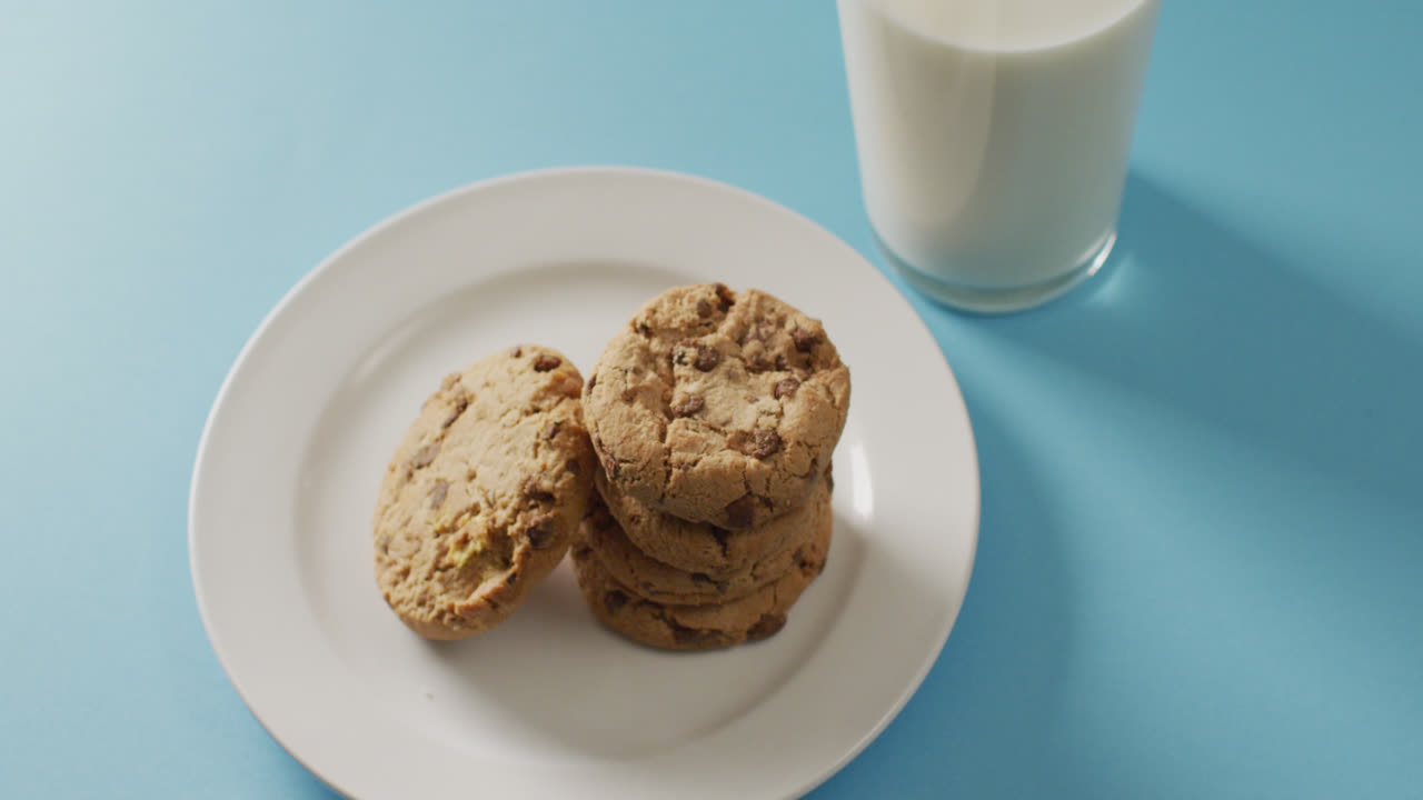 Video of biscuits with chocolate and milk on blue background