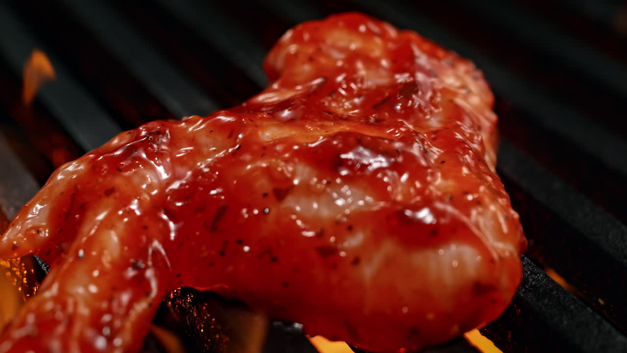 Marinated Chicken Wing Barbecuing On The Charcoal Grill Among Fire Flames in Slow Motion, BBQ in Macro