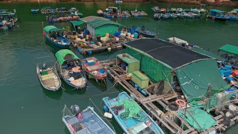 Aerial-over-the-fishing-boats-and-rafts-of-the-fish-farms-on-Ma-Wan-island,-Hong-Kong,-China