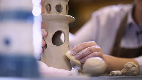 woman creating a clay lighthouse