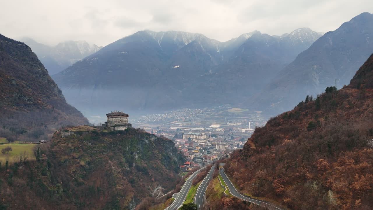Building on the hill with a beautiful landscape in the background, filmed in the Italian Alps (drone footage)