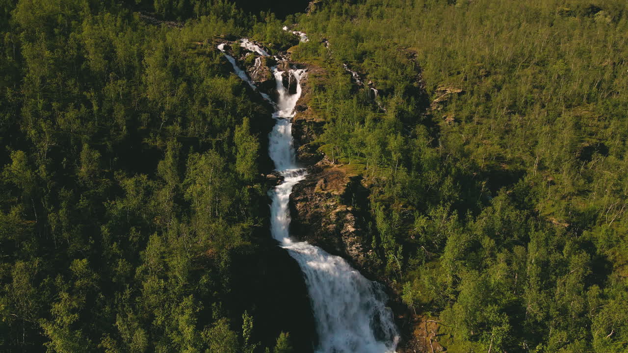 arroyos espumosos de turelva sobre acantilados escarpados entre vegetaciones en finnmark, noruega