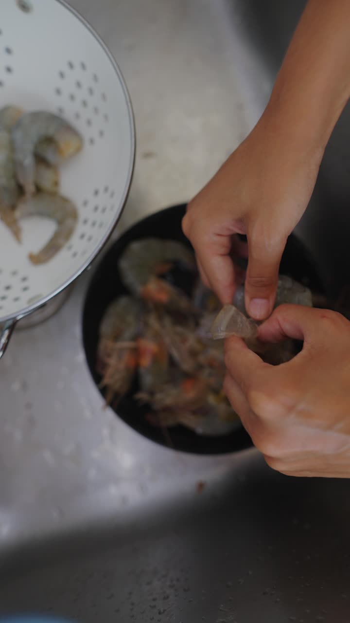 Hands Cleaning and Preparing Shrimp in a Kitchen Sink