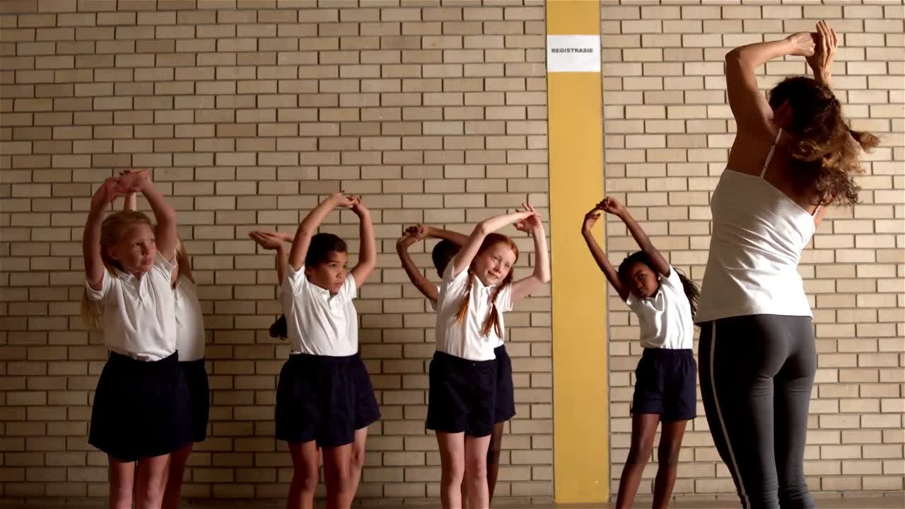 귀여운 학생들이 pe 선생님과 함께 따뜻해지고 있습니다.