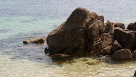 a series of eroded rocks and the sea lapping around then on the beach on st agnes at the isles of scilly 1 of 6