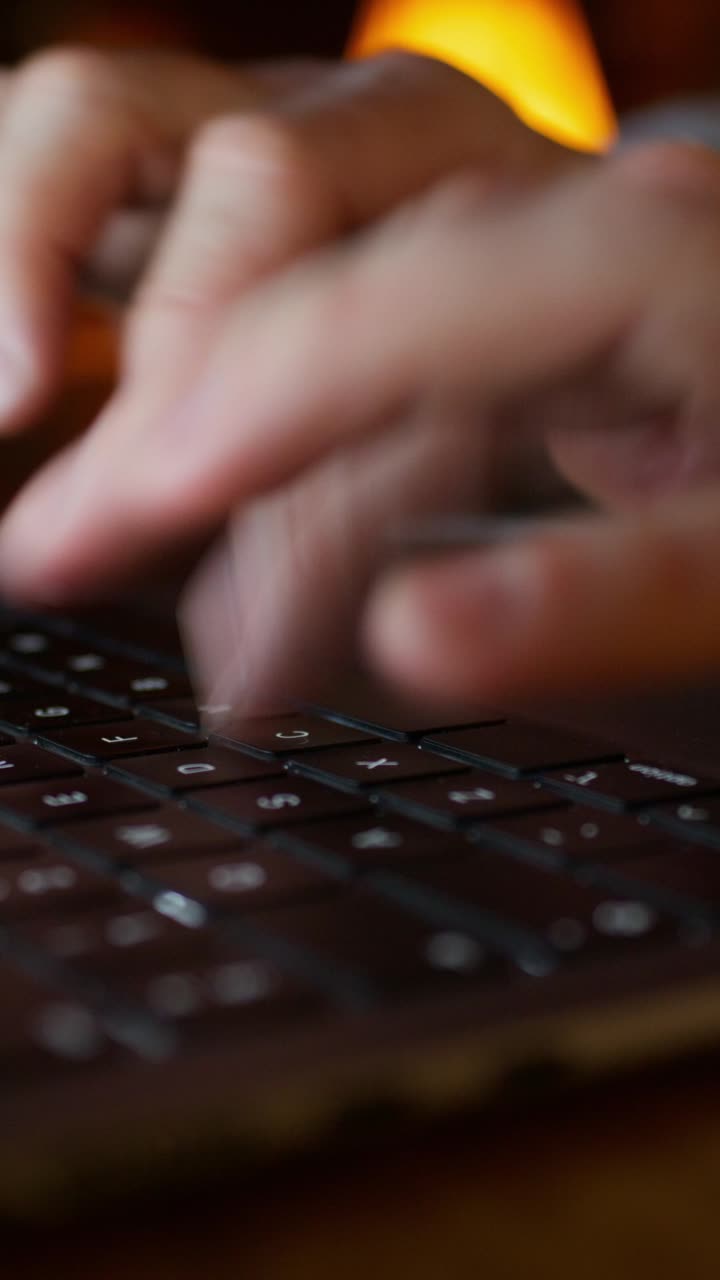 Person Typing on Laptop Keyboard at Night