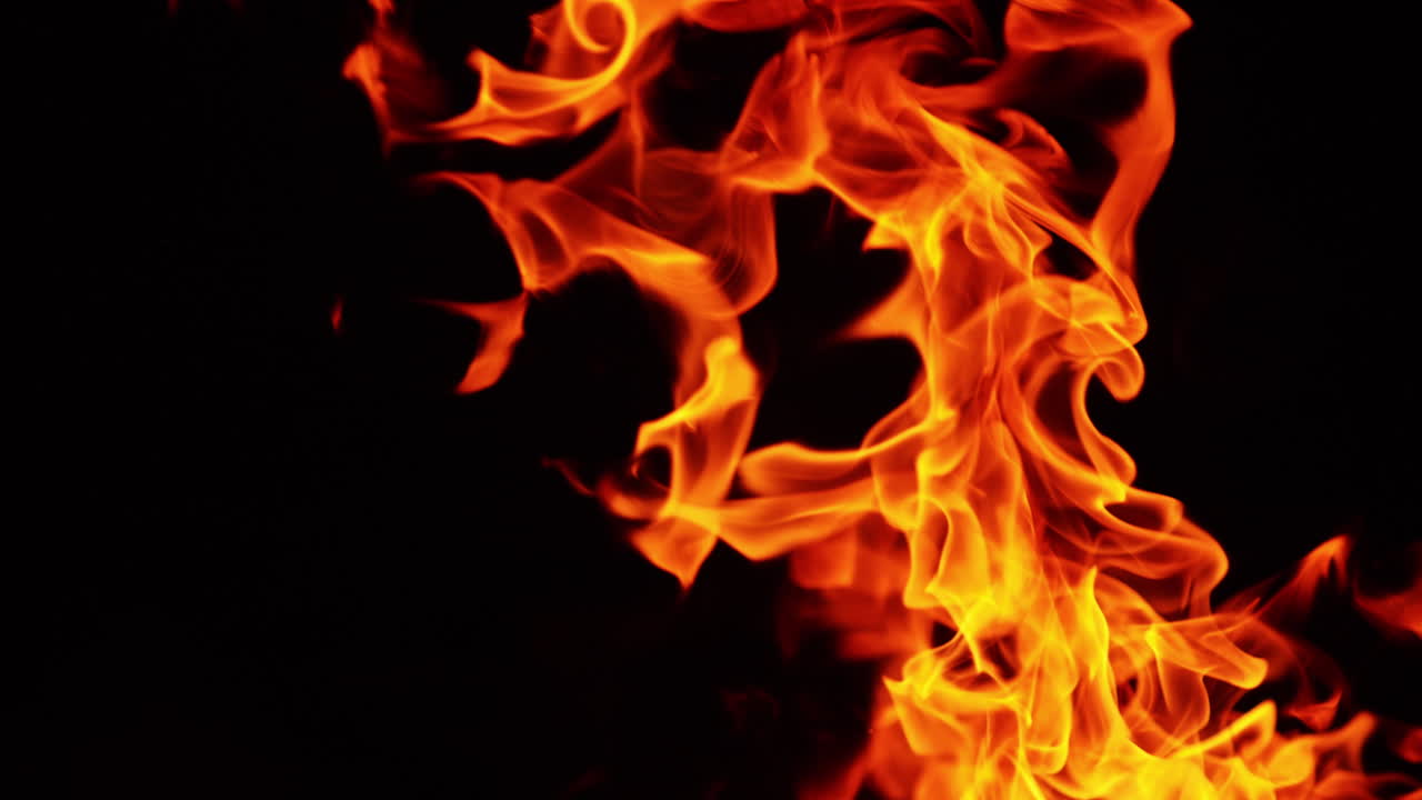 Flames and sparks reaching into the air. Burning bonfire isolated on the black backdrop.