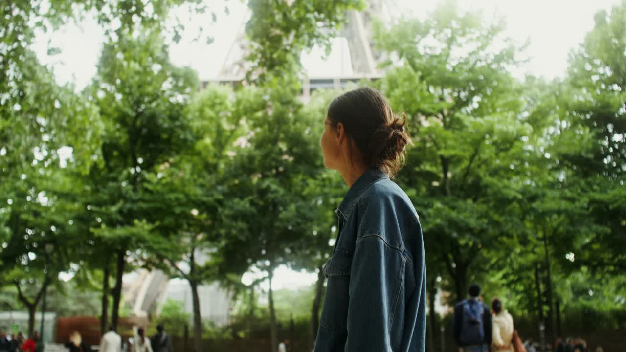 mujer mirando la torre eiffel en parís
