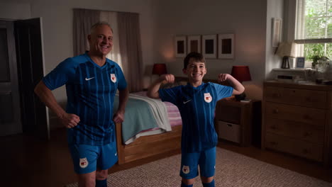 father and son flexing in soccer uniforms