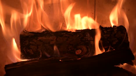 llama de fuego ardiendo trozo de madera picada en la chimenea en casa un primerísimo plano