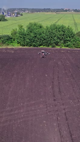 tractor tilling center of farm field in the fall