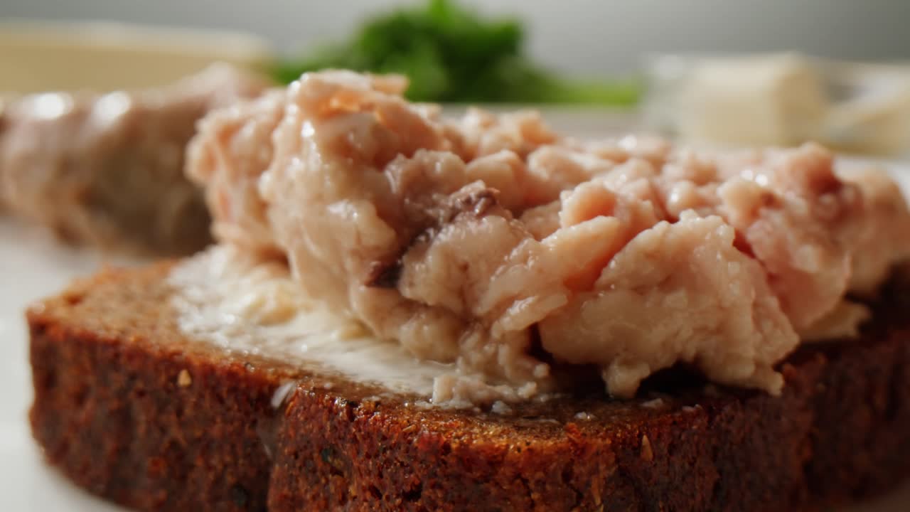 Smoked cod liver in oil in open tin can with fresh greens on wooden table. Seafoods delicacy. High quality 4k footage