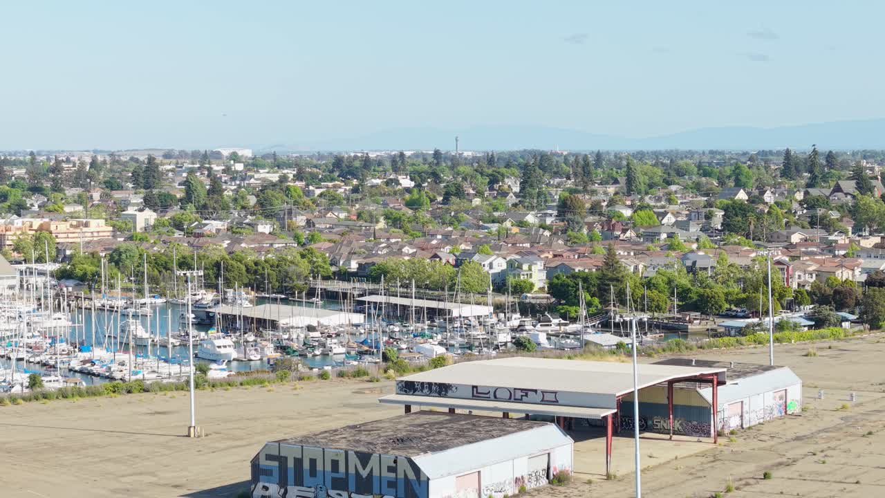 A slow aerial panning shot highlighting boats, buildings and neighborhood of Mariner Square in Alameda, California.